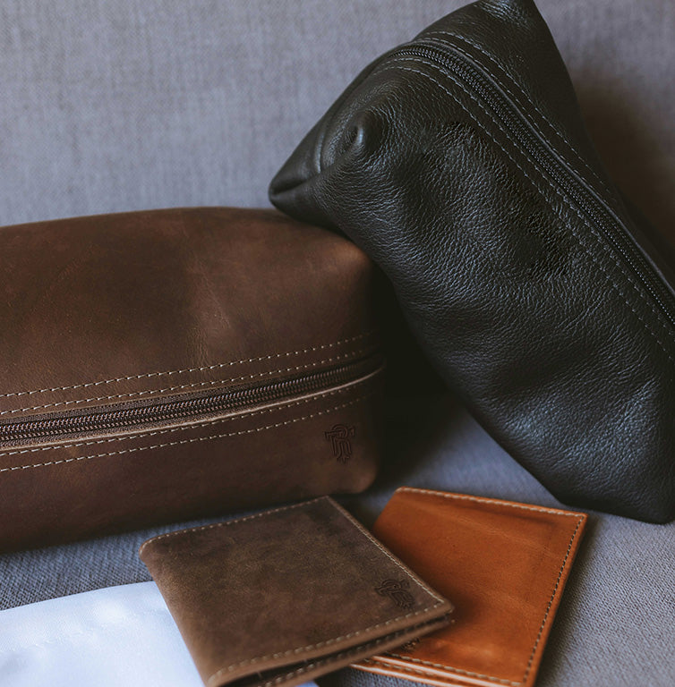 Three leather pouches in brown and black on a gray surface