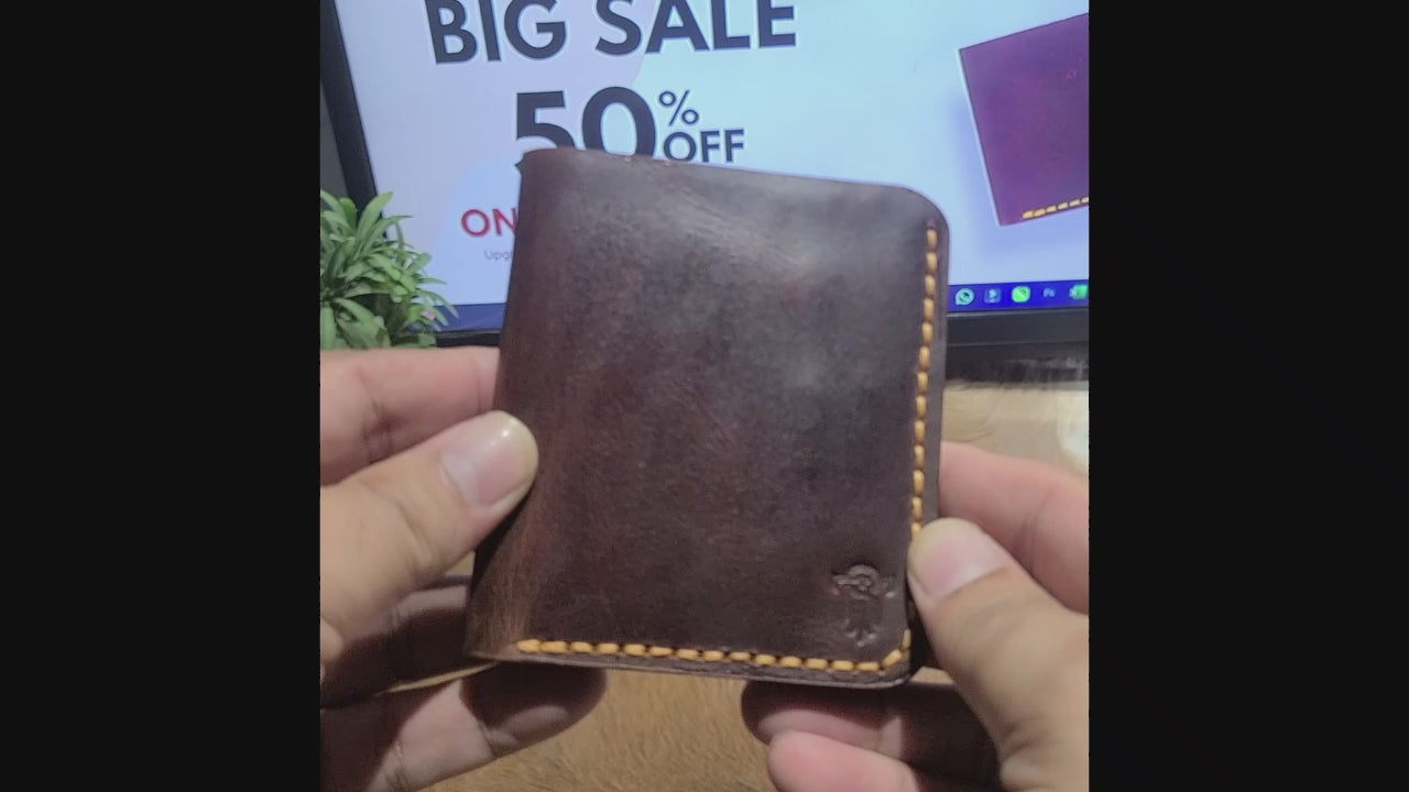Hand holding brown leather Article No 801 wallet in front of 50% off sale sign. Stylish handcrafted wallet ideal for gifting.
