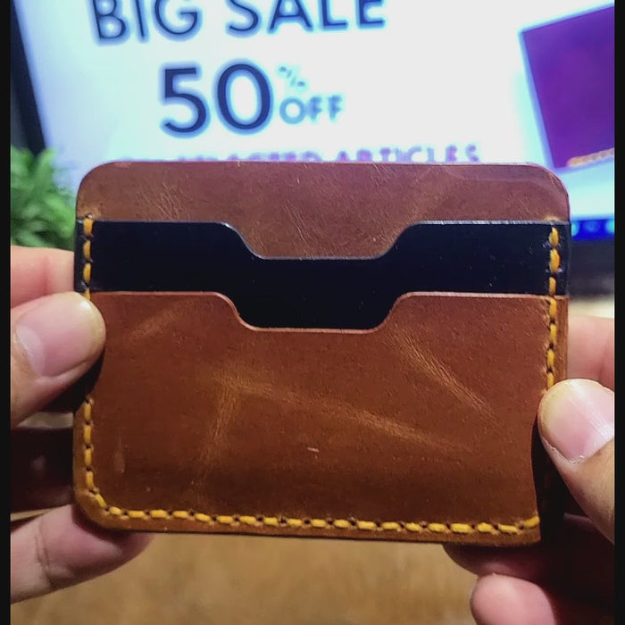 Slim Leather Card Holder Article No 806 in brown with yellow stitching, showcasing two card slots and a minimalist handcrafted design.