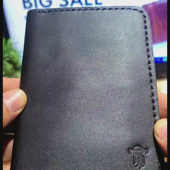 Close-up of Article No 902 Leather Passport Cover in black, highlighting premium craftsmanship and embossed logo for a stylish travel accessory.