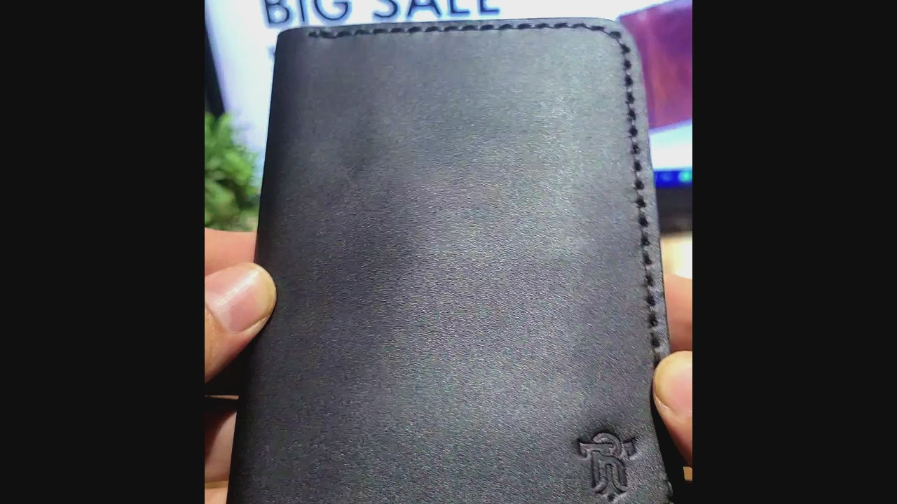 Close-up of Article No 902 Leather Passport Cover in black, highlighting premium craftsmanship and embossed logo for a stylish travel accessory.